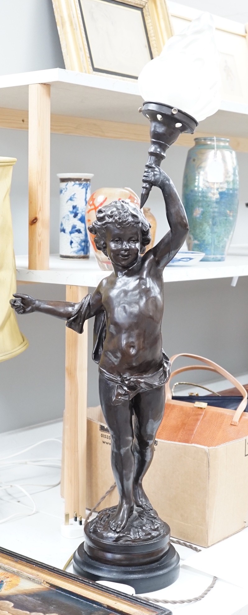 A bronzed composition cherub table lamp with frosted glass shade Height 88 cm.